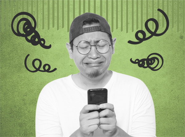 スマホを持って泣く男性画像